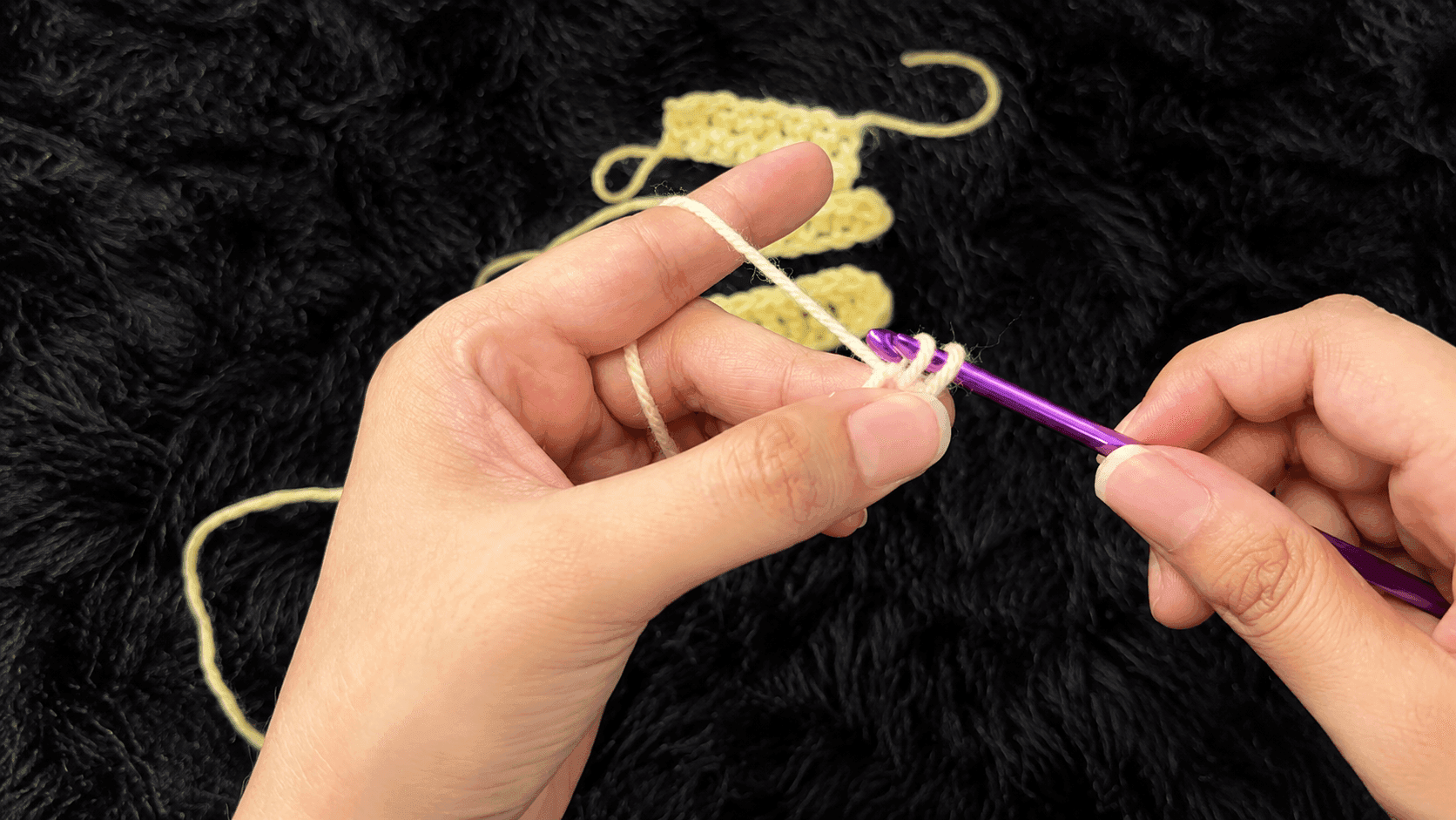 Hands demonstrating the slip stitch technique with a purple crochet hook and cream yarn, showing how to join rounds and create seamless connections.