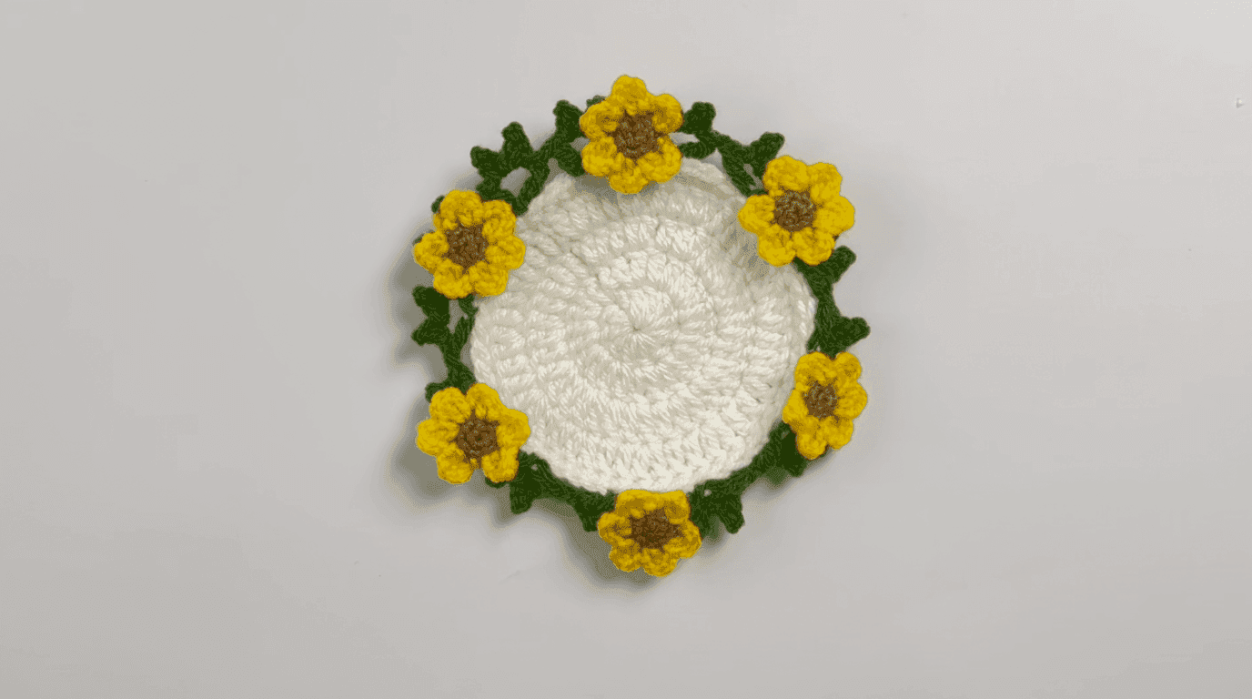 Crochet sunflower pot assembly in progress: yellow flowers being positioned evenly around beige pot base showing spacing technique