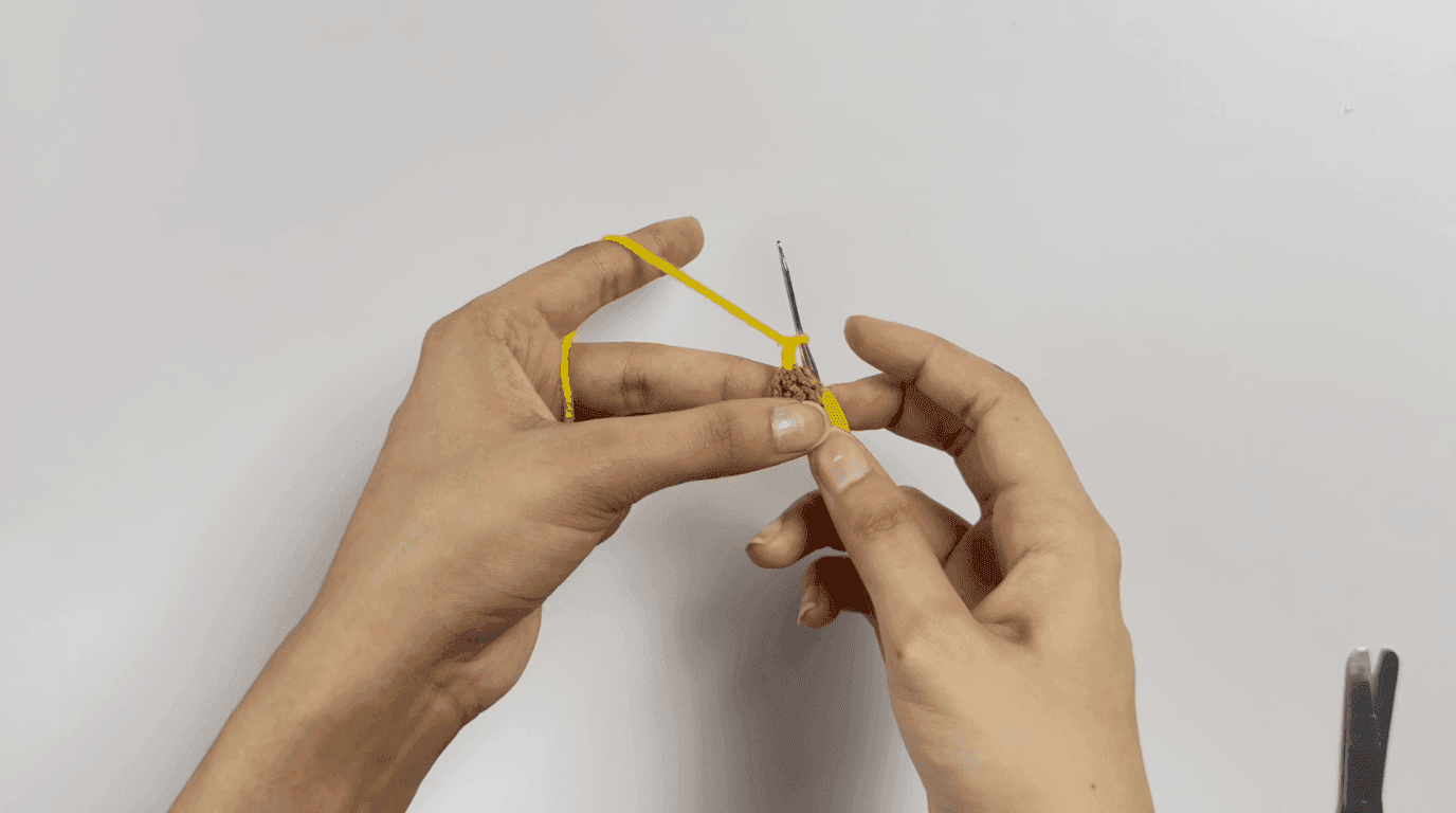 Crochet mini sunflower petals: hands working yellow chain-2, double crochet petal sequence around brown core with 2.0mm hook