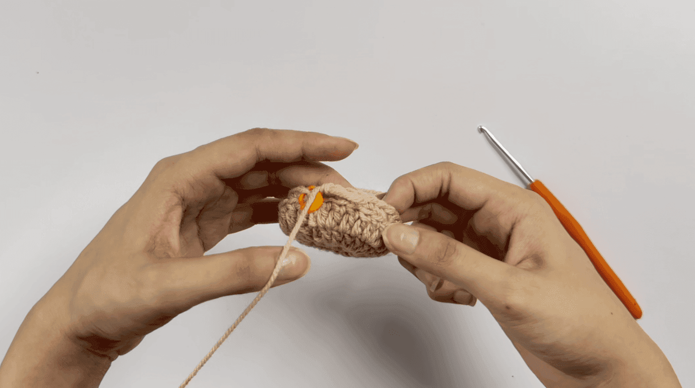 Crochet sunflower pot Round 5: hands working back-loop-only (BLO) single crochet creating visible ridge on beige pot base
